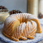Eggnog Bundt Cake next to a glass of eggnog