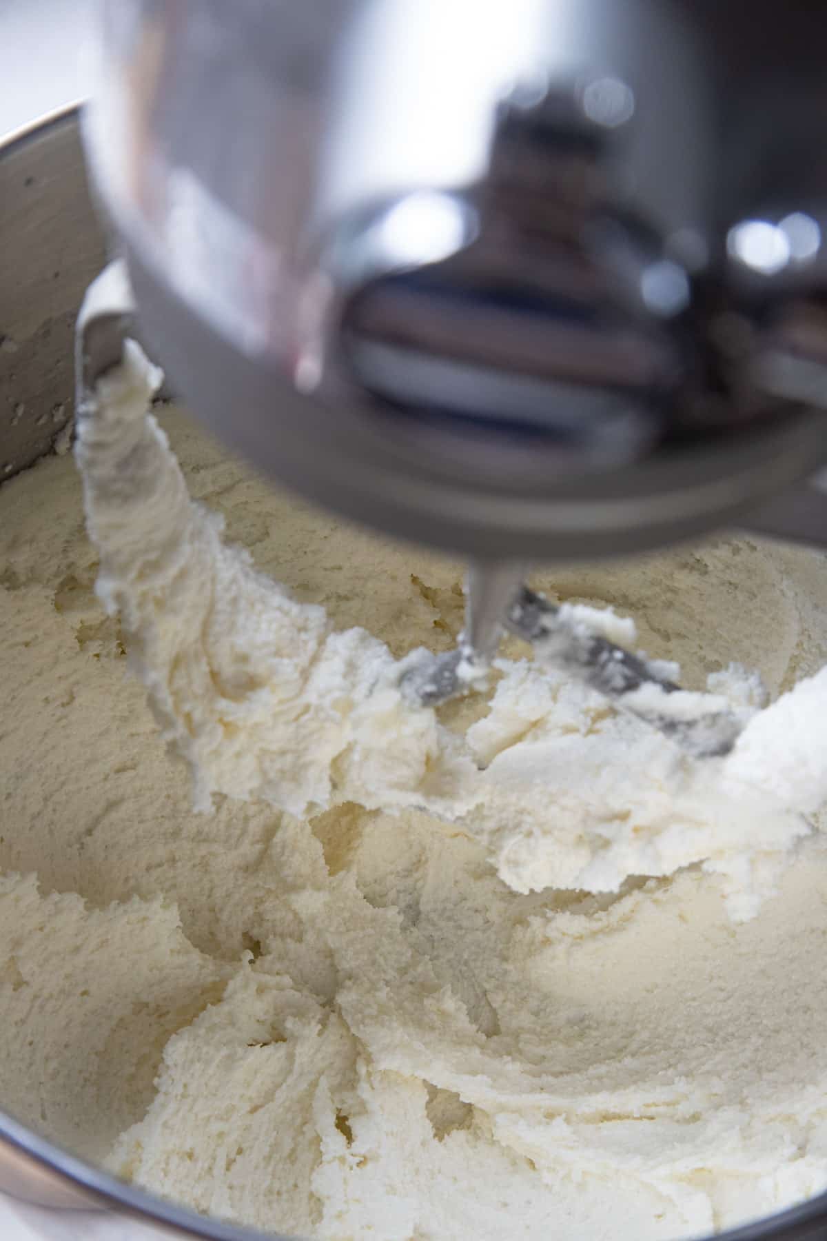 Creamed butter and sugar in the bowl of a stand mixer. It is almost white and looks fluffy.