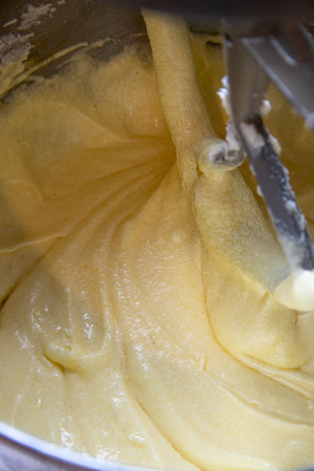 The cake batter after the eggs have been mixed it. It looks creamy and is a light yellow