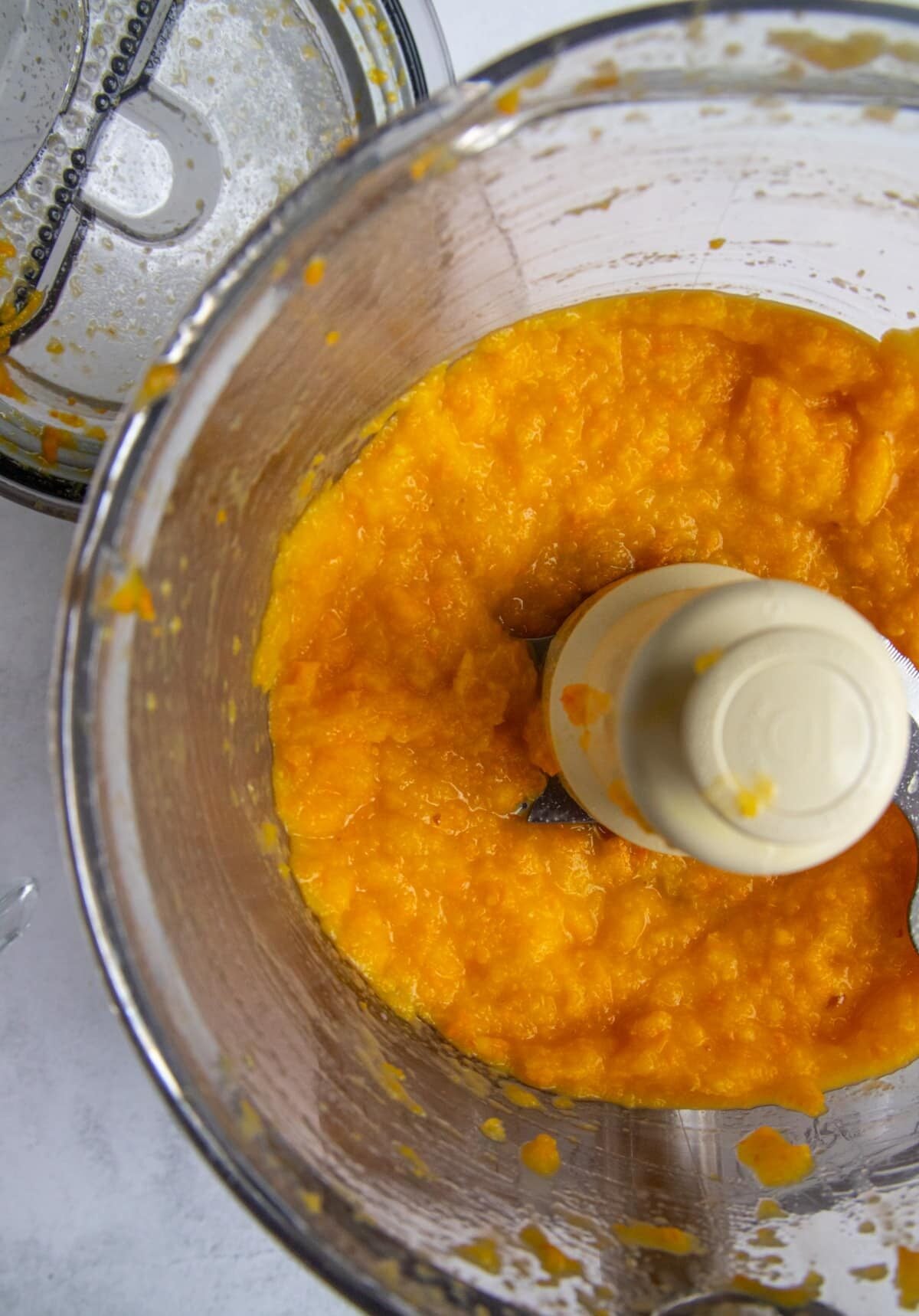 Clementine mandarin oranges pureed in the bowl of a food processor