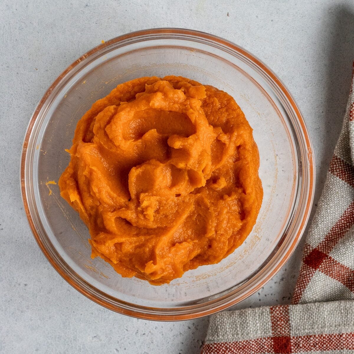 Pureed sweet potato in a glass bowl