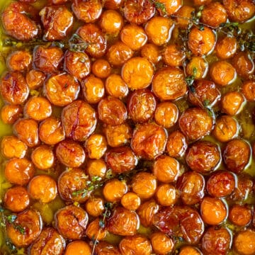 A ceramic roasting pan filled with roasted cherry tomatoes