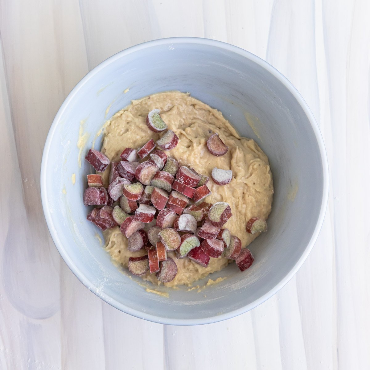 chopped rhubarb added to the muffin batter, the rhubarb is dusted with flour