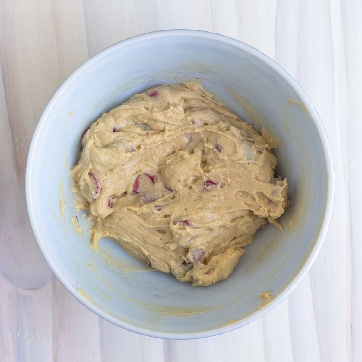 the rhubarb muffin batter in a white ceramic mixing bowl