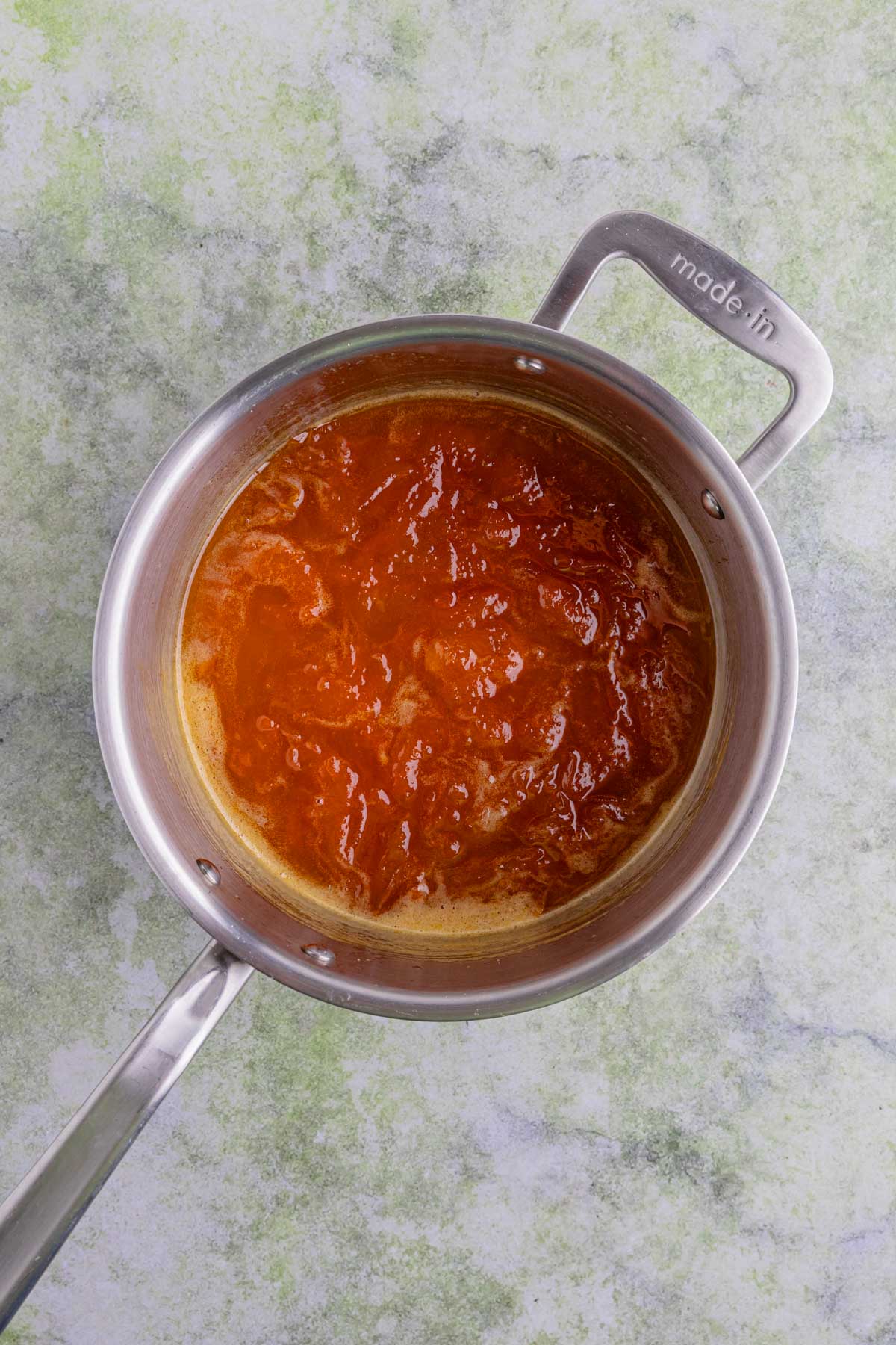 Cooked apricot jam in a stainless steel saucepan