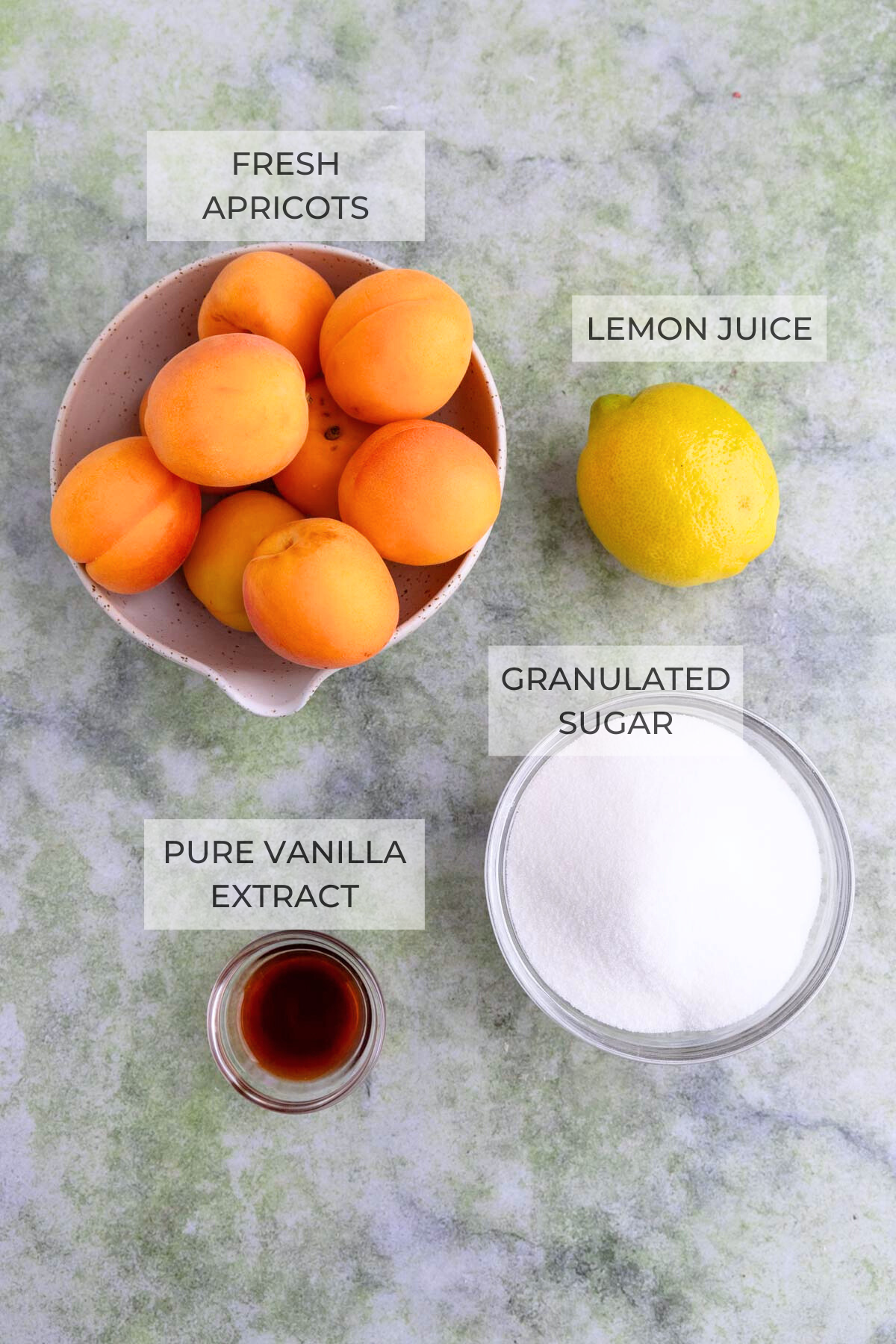 Apricot jam ingredients - fresh apricots, sugar, a lemon, and vanilla extract.