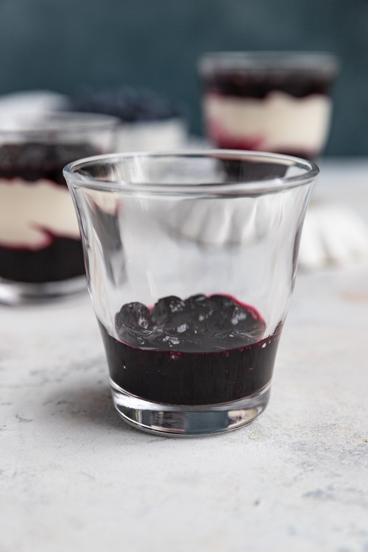 A glass container filled with 2 tablespoons of blueberry compote