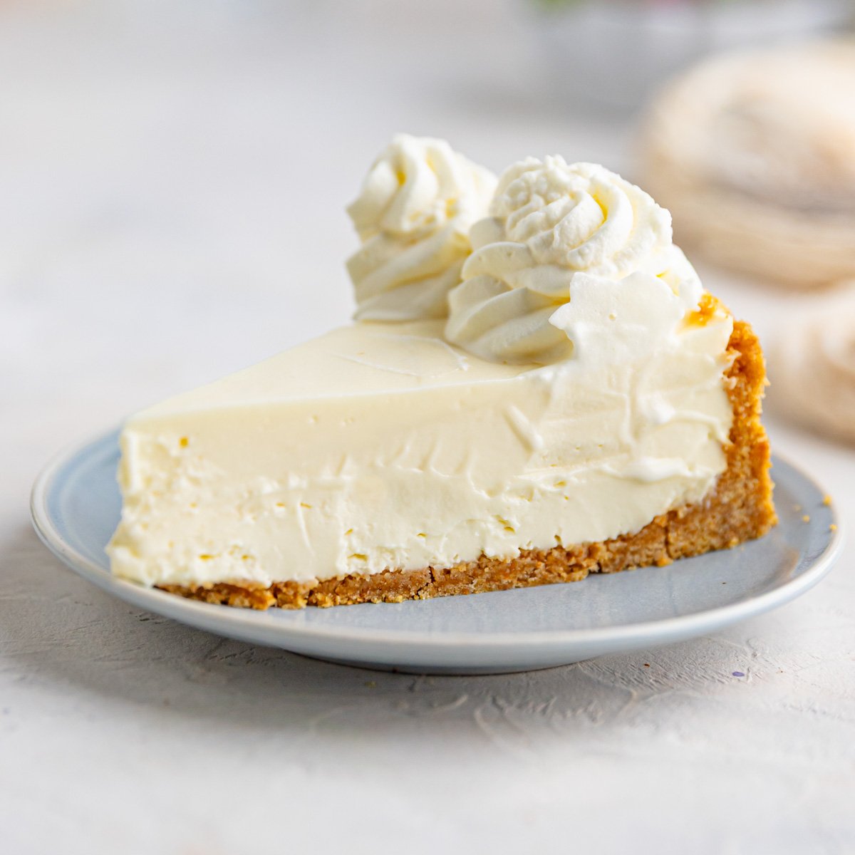 No-bake cheesecake on a light blue plate topped with whipped cream