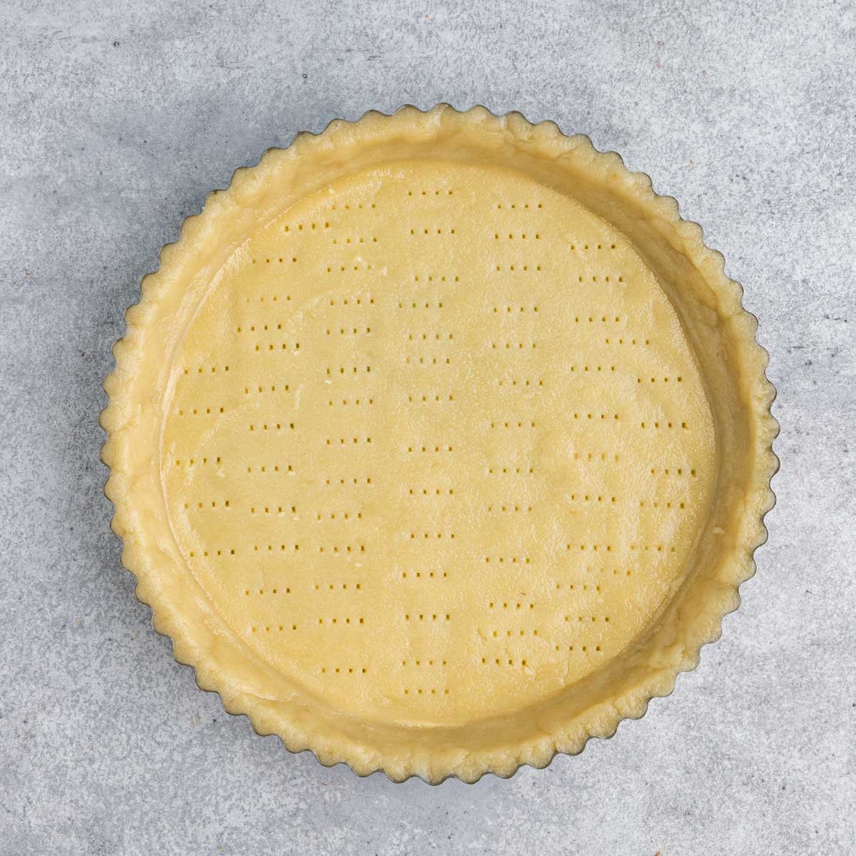 Unbaked tart dough  pressed into a 9-inch pan.  The bottom of the dough is docked several times with a fork