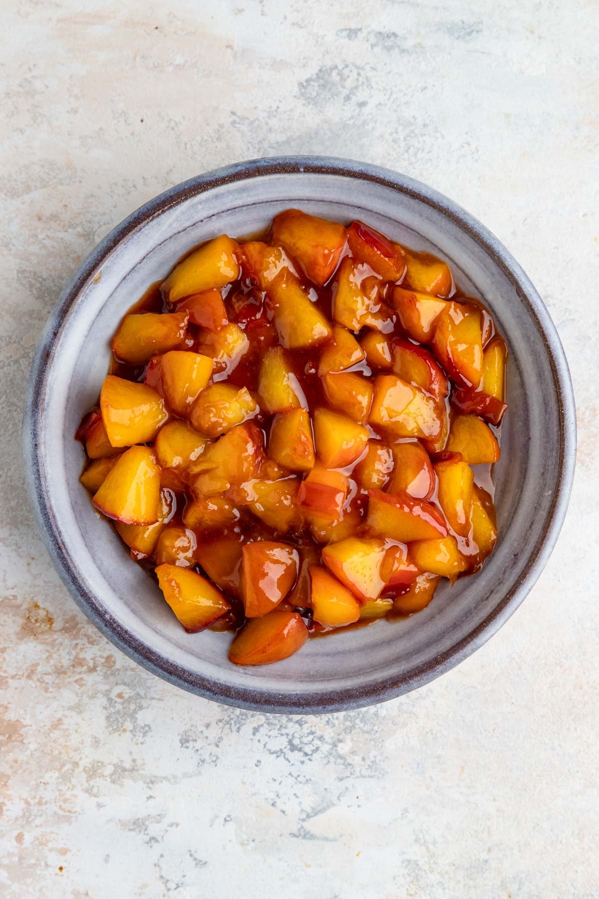 Cooked cooled peaches in a blue ceramic bowl