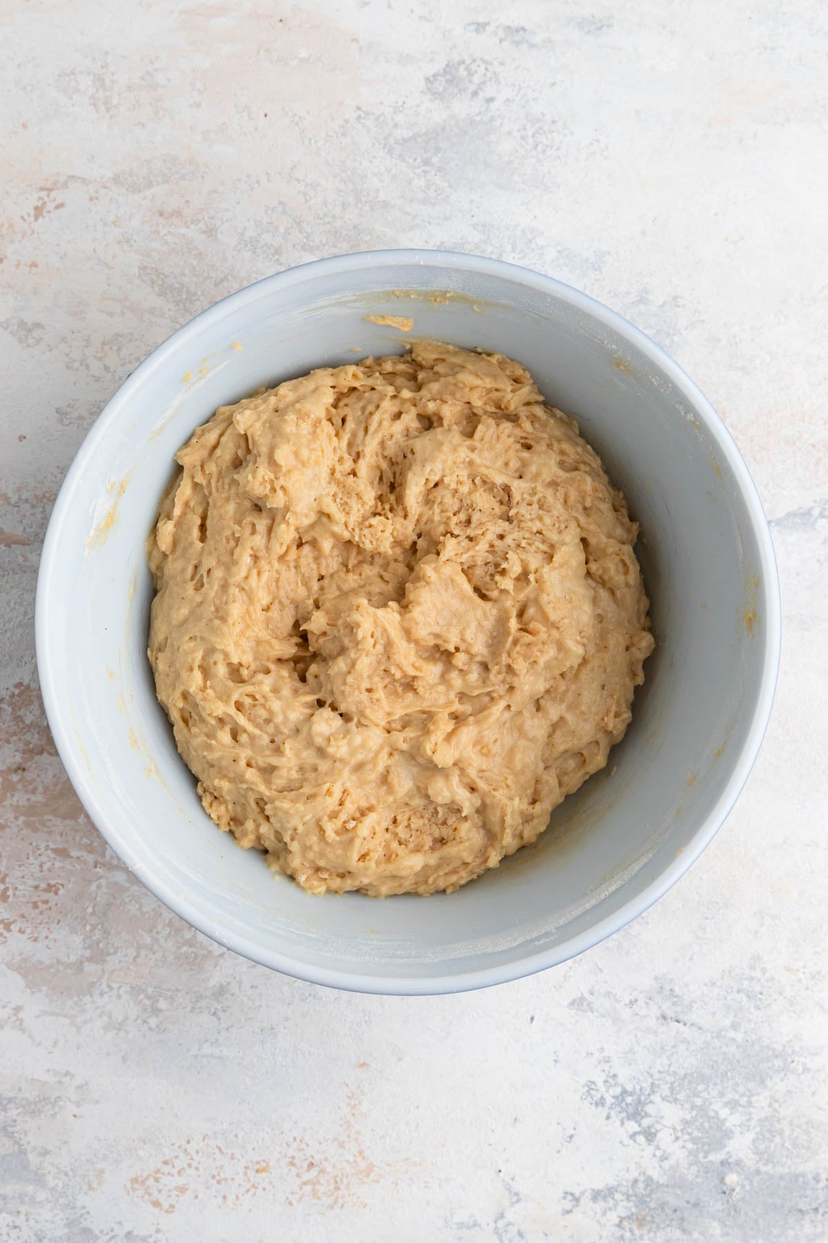 Muffin batter in a white ceramic bowl. The batter looks thick and is slightly lumpy