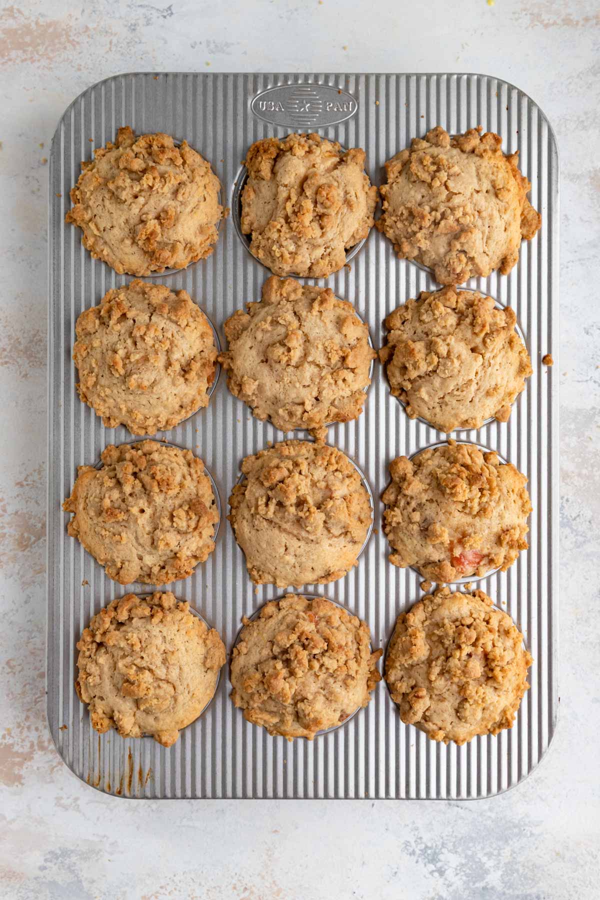 Baked peaches in muffin tin. The peaches are golden brown and domed