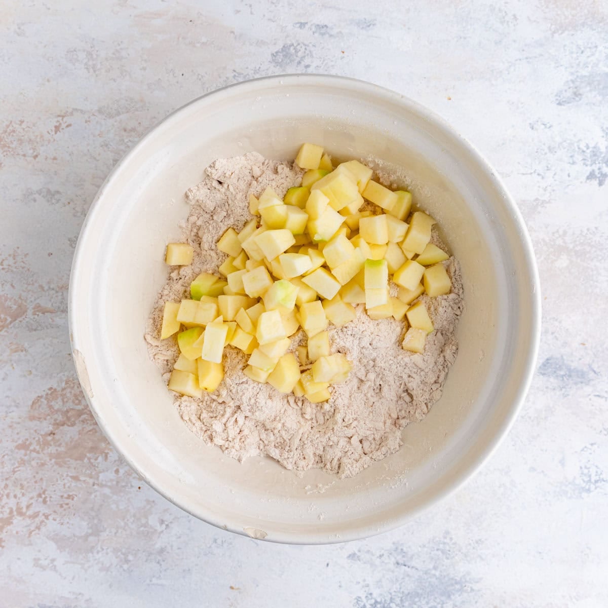 The cubed fresh apples added to the dry ingredients.