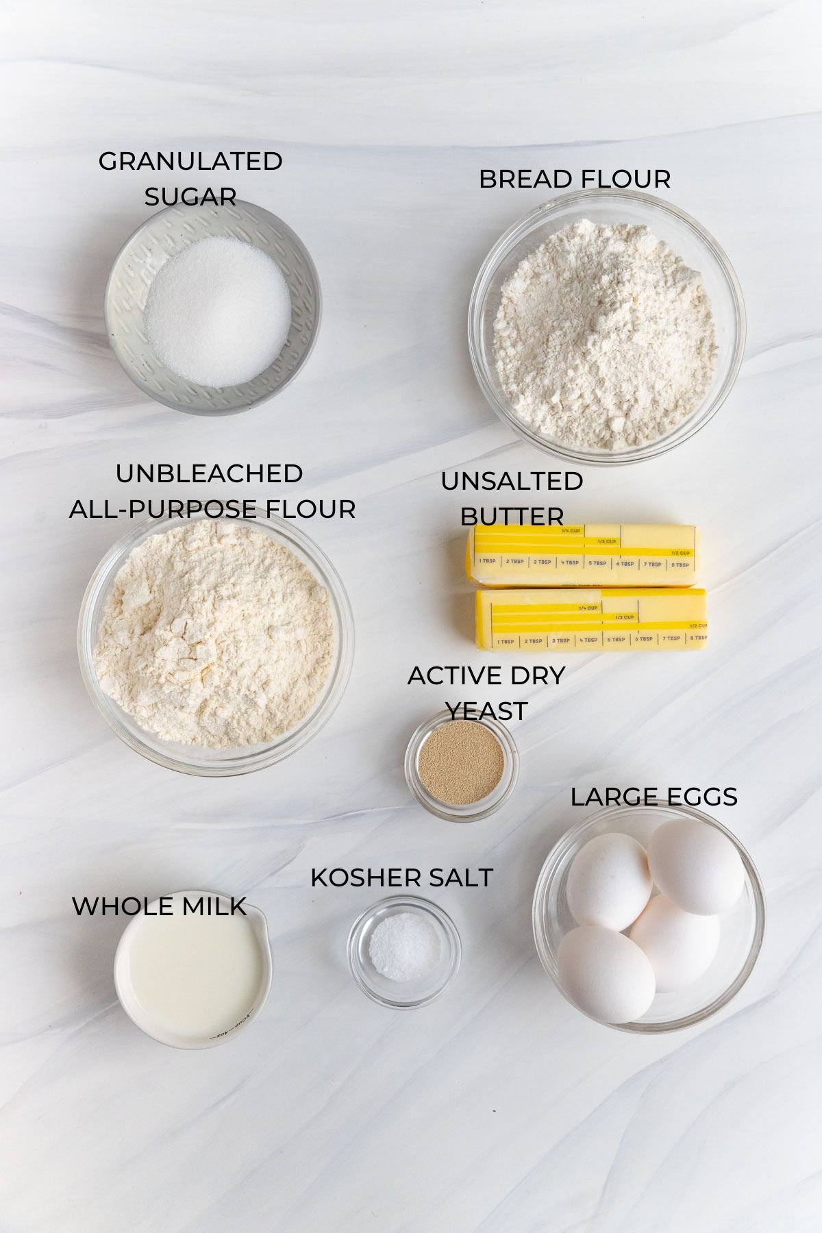 Brioche dough ingredients (clockwise) - bread flour, unsalted butter, active dry yeast, large eggs, kosher salt, whole milk, unbleached all-purpose flour, granulated sugar