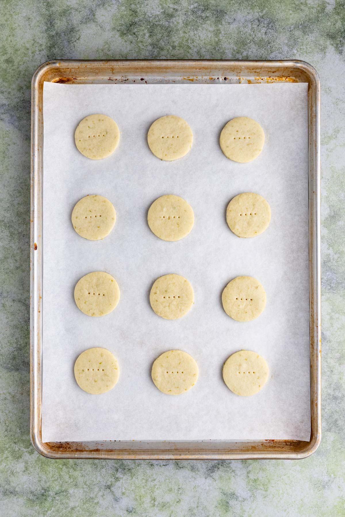 Twelve baked cookies on a parchment lined half baking sheet