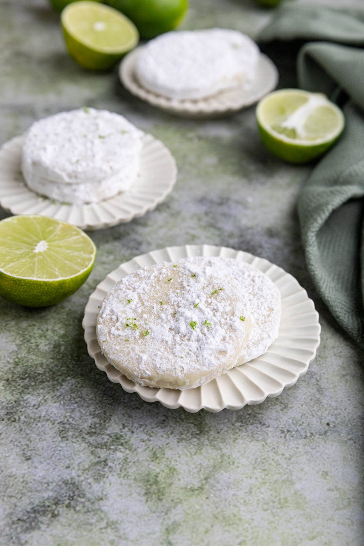 Two small plates with 2 lime shortbread cookies on each plate