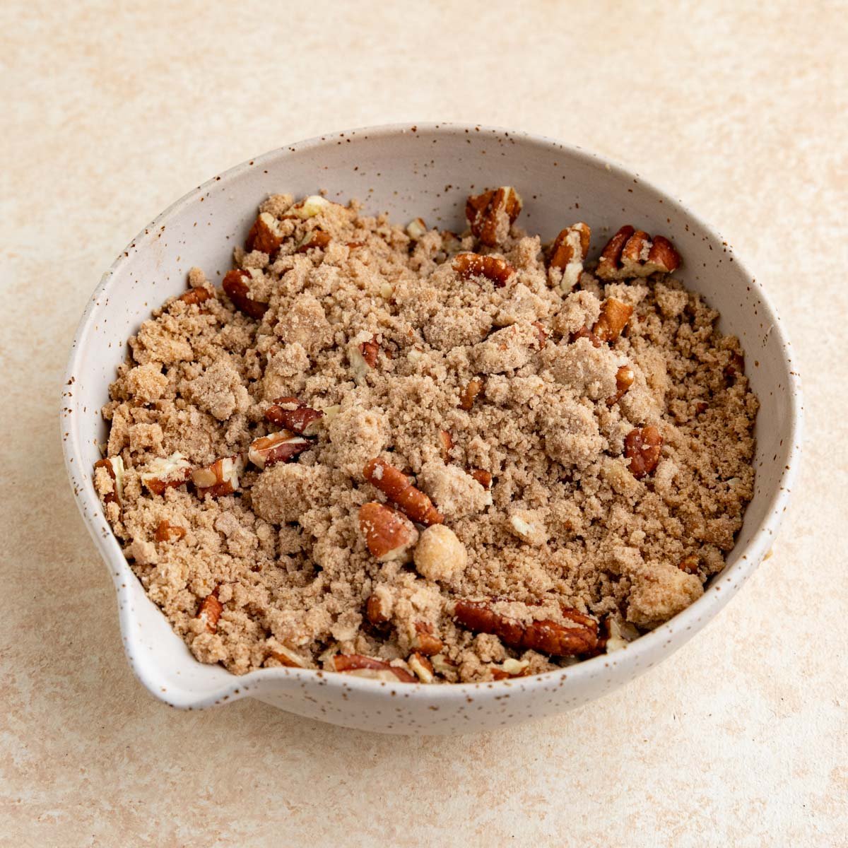 Pecan streusel in a beige colored ceramic bowl