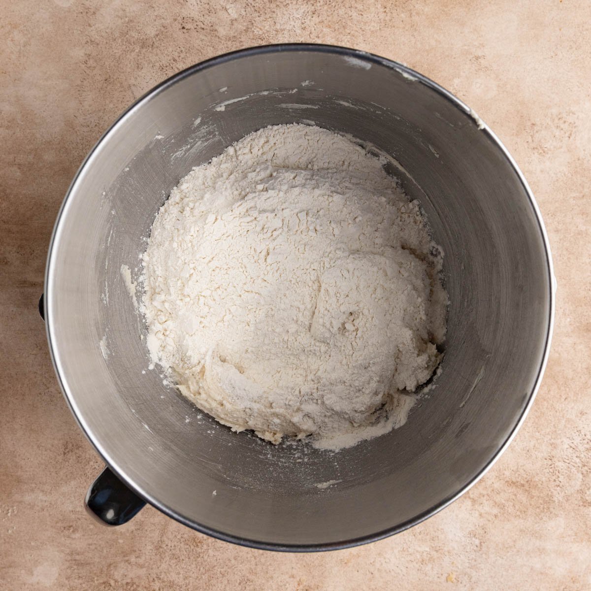 Flour on top of the creamed butter and sugar and eggs in the stainless steel bowl of a mixer