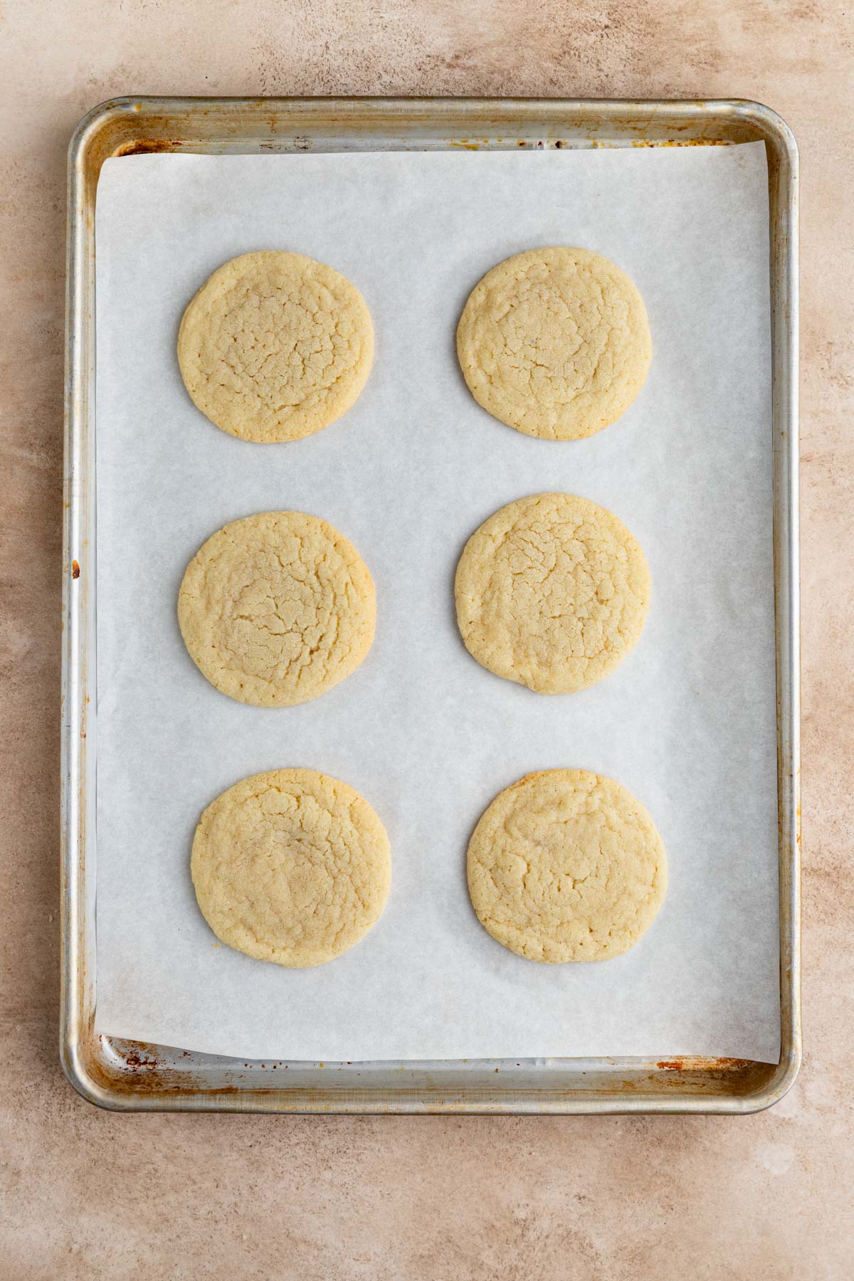 Six baked cookies on parchment lined baking sheet