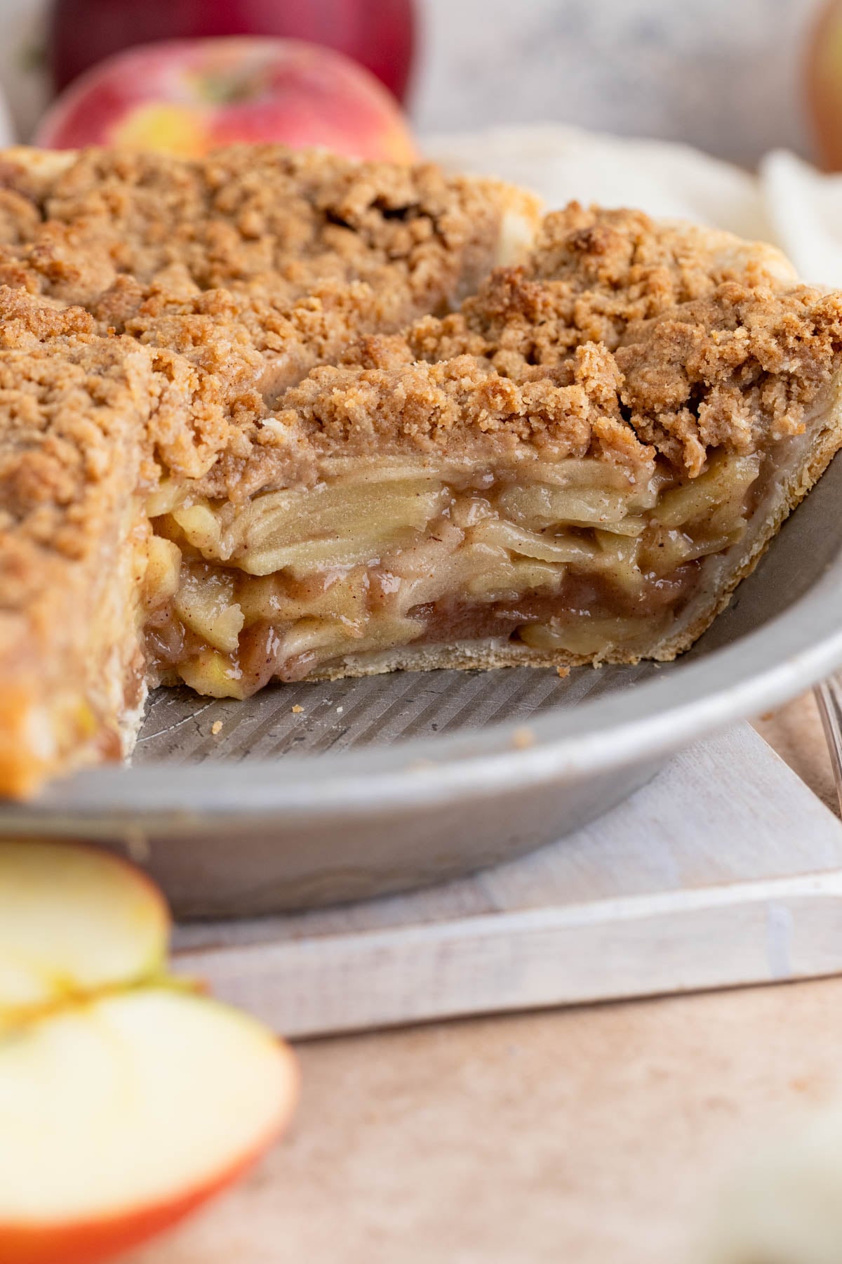 A close up of the cut pie in the pie pan with the layer of apples. The pie plate is gray with ridges.