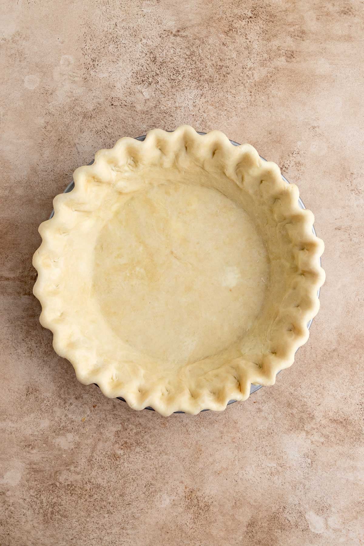 An unbaked pie crust with fluted edges in a pie pan