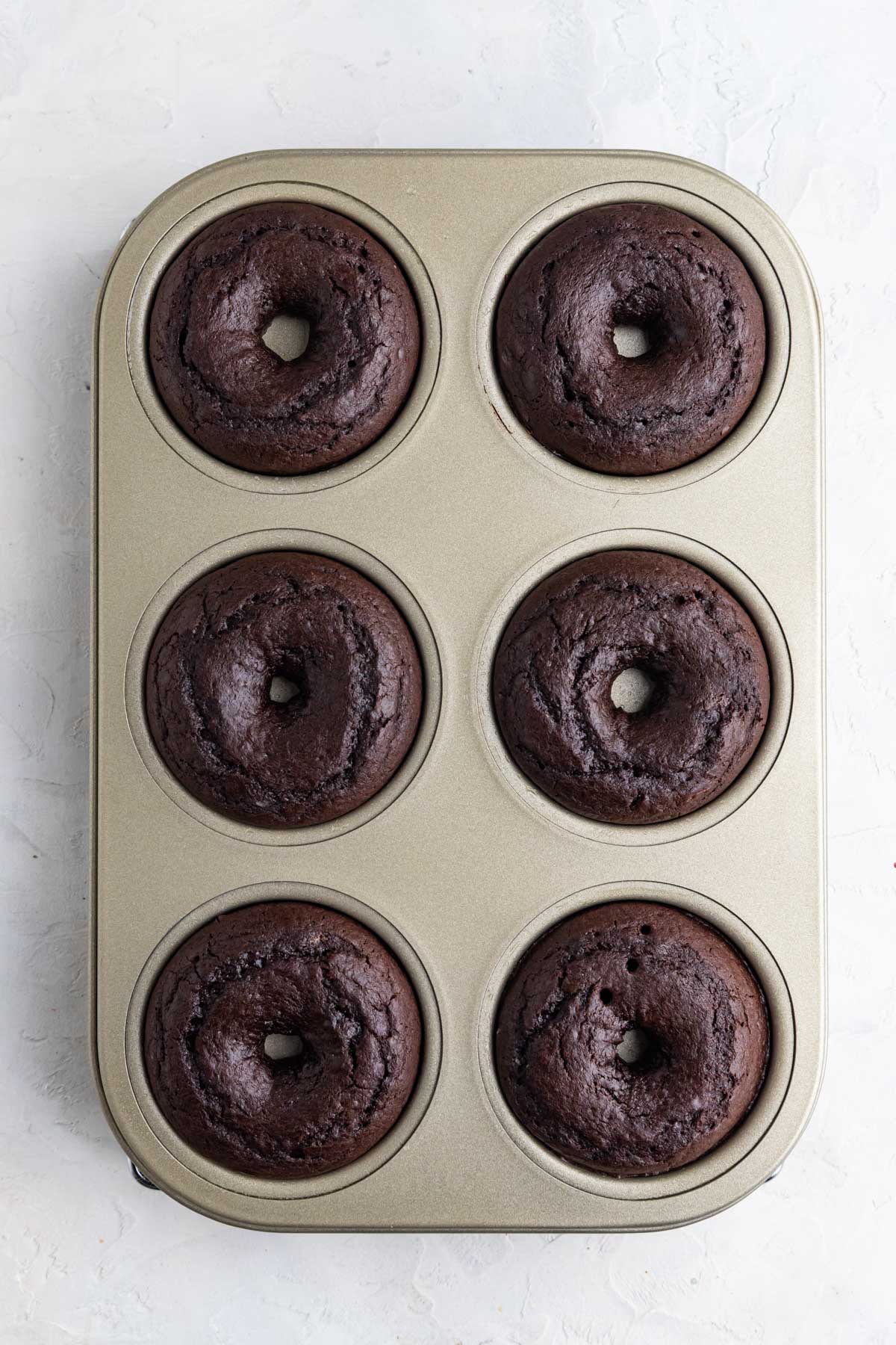 Baked chocolate doughnuts in a 6 doughnut baking pan