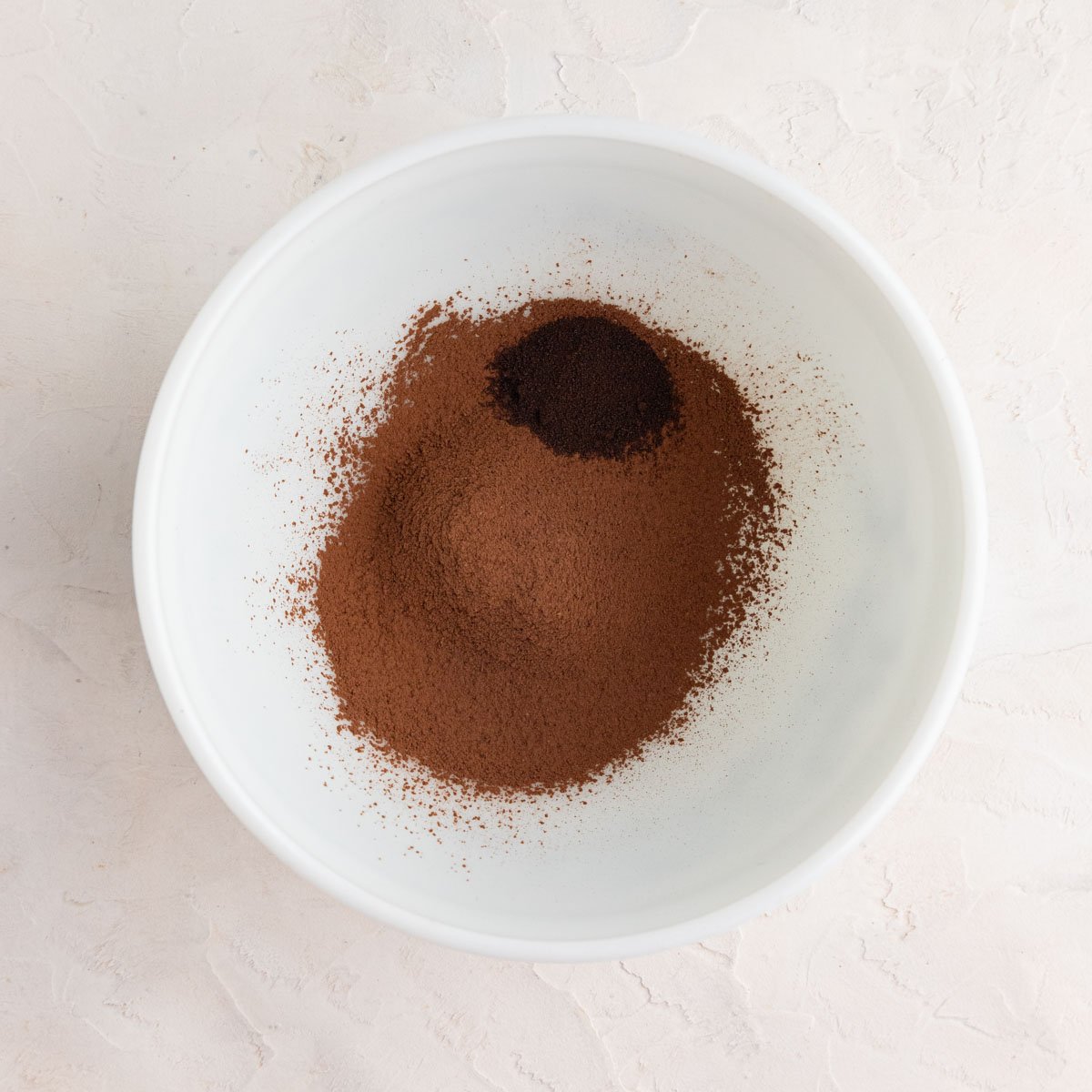 Dutch processed cocoa powder and instant espresso powder in a white ceramic bowl