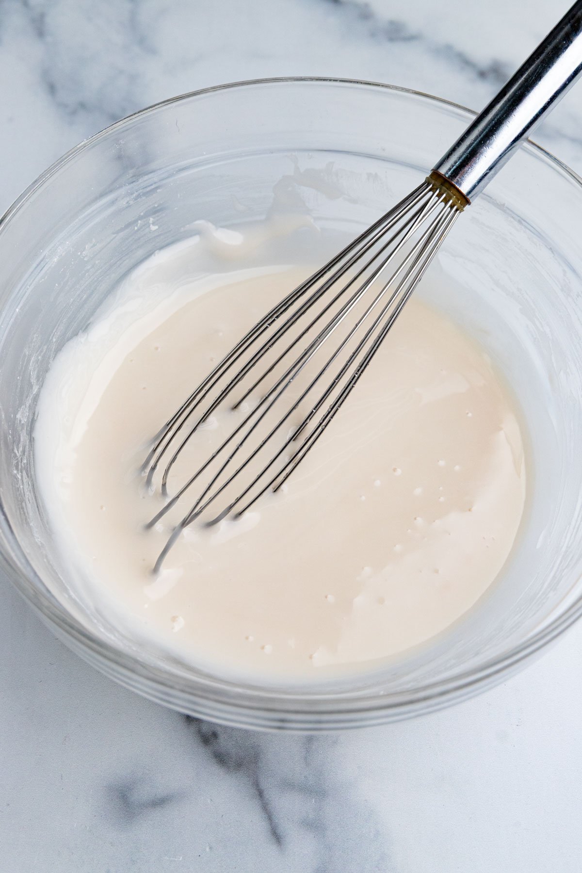 A glass bowl filled with white vanilla cookie icing