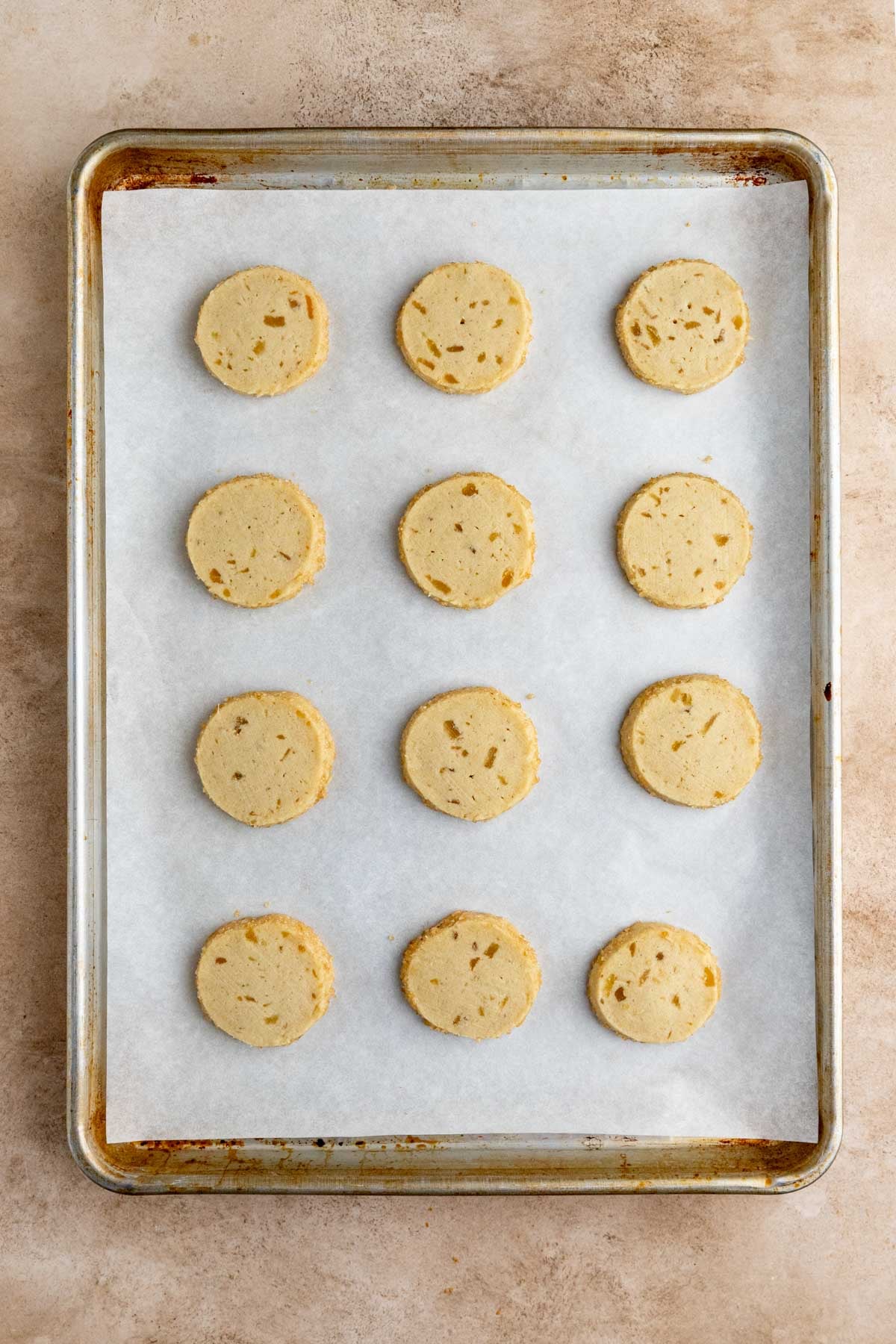 Twelve baked ginger shortbread cookies on a parchment lined baking sheet