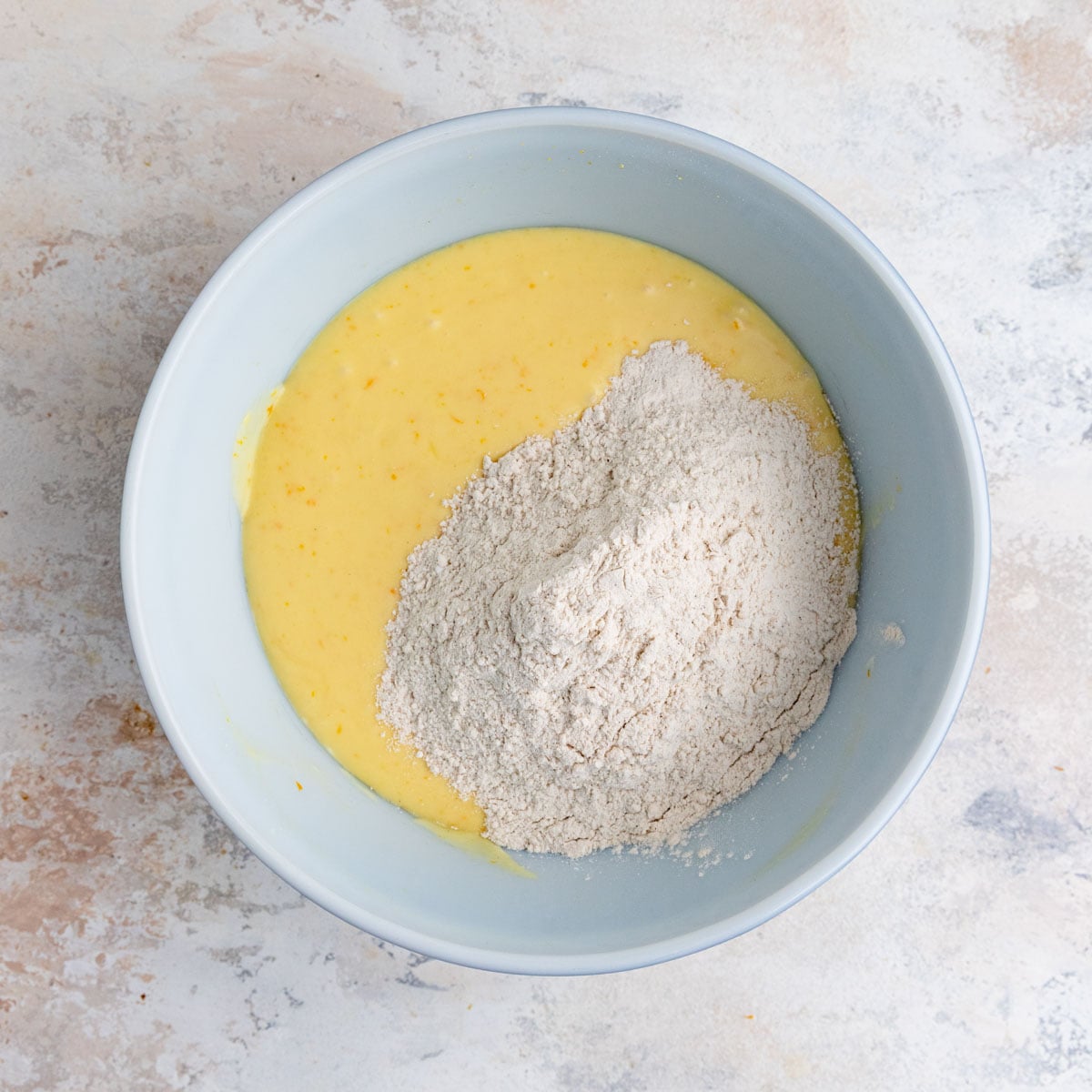 Orange muffin batter with the dry ingredients added to the batter