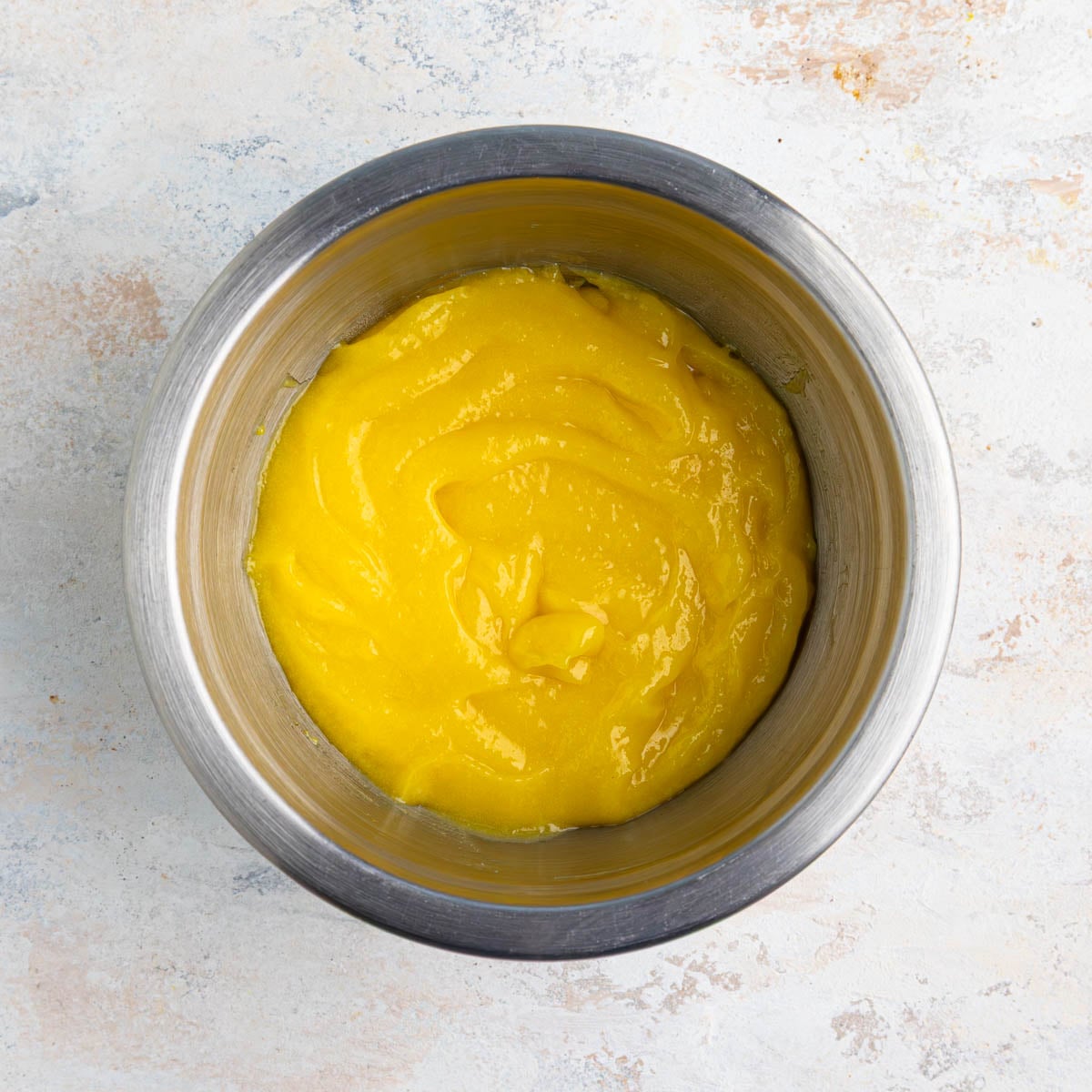 Lemon curd in a stainless steel bowl