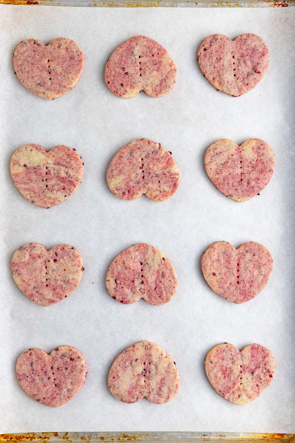 Twelve baked cookies on a parchment lined baking sheet