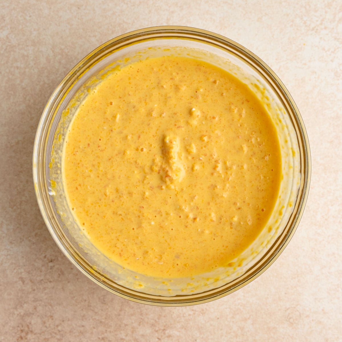 A mixture of pureed Clementines, sour cream, and vanilla extract in a small bowl