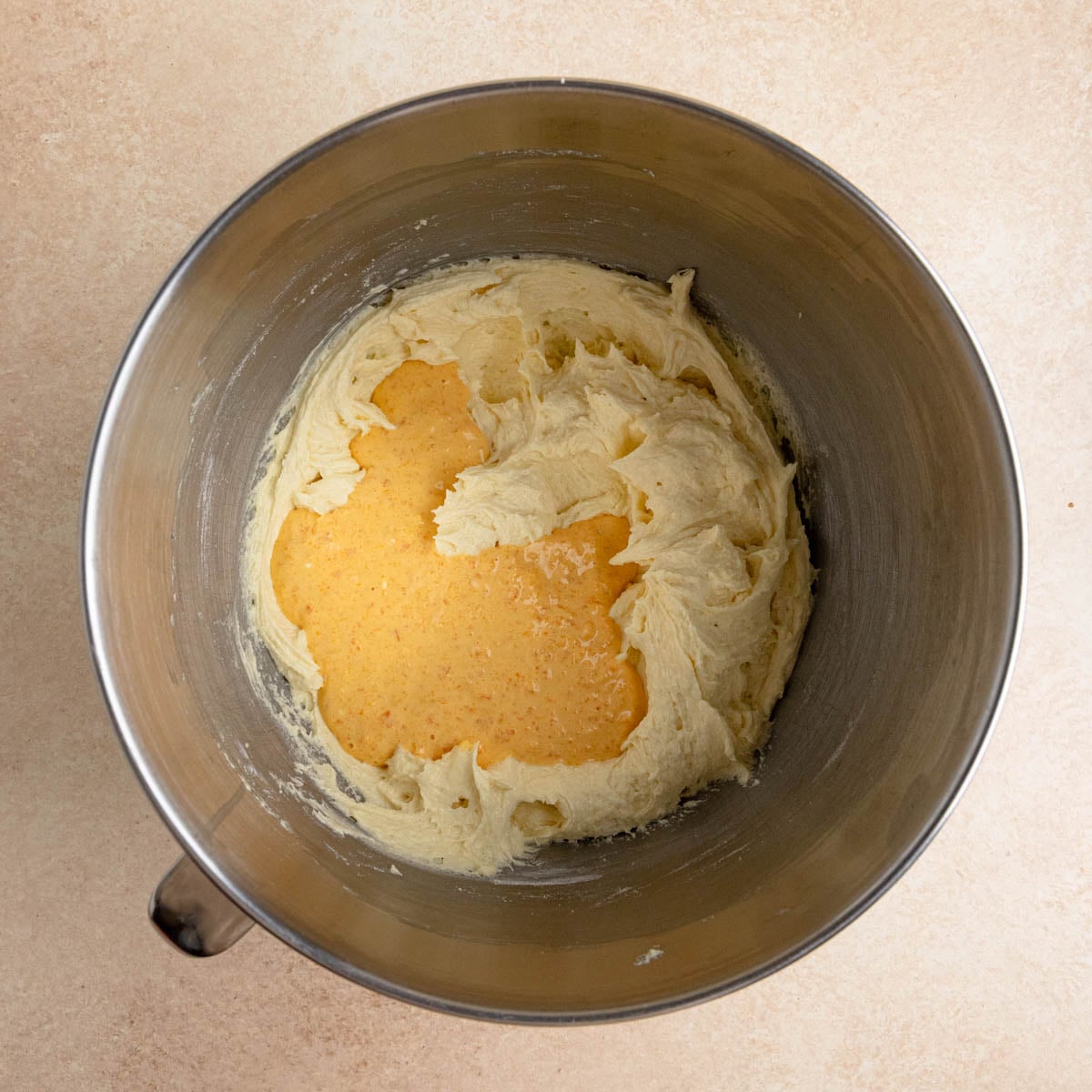 The cake batter with half of the orange-sour cream mixture added on top