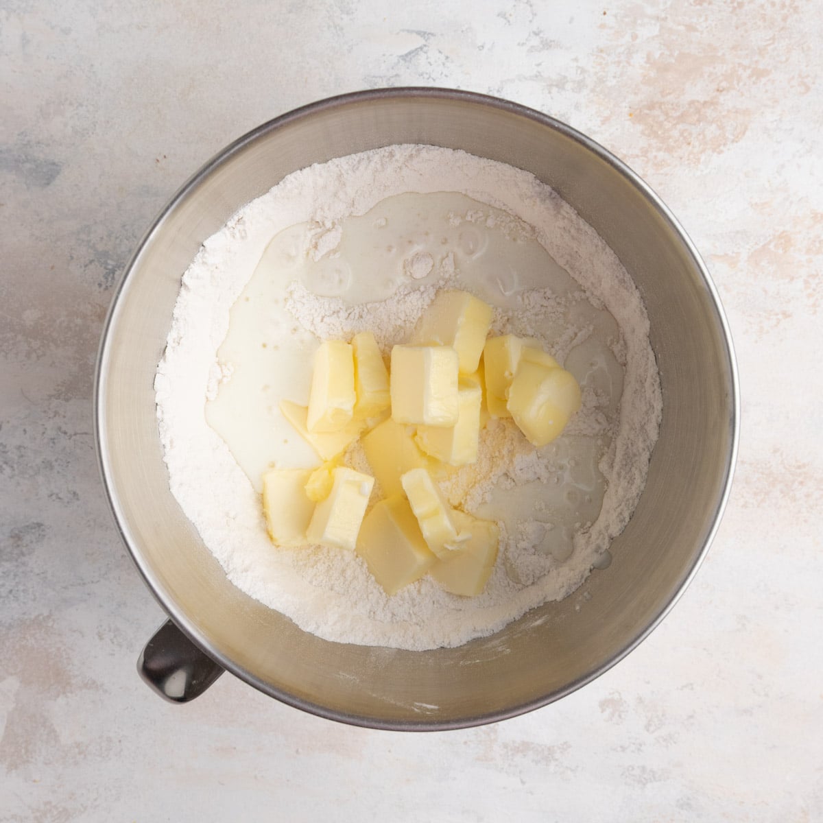 Butter and buttermilk added to the cake's dry ingredients in the bowl of a stand mixer