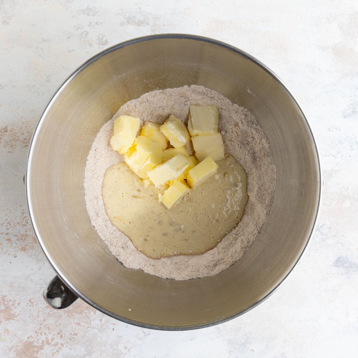 Butter and part of the banana mixture added to the dry ingredients in the stainless steel bowl