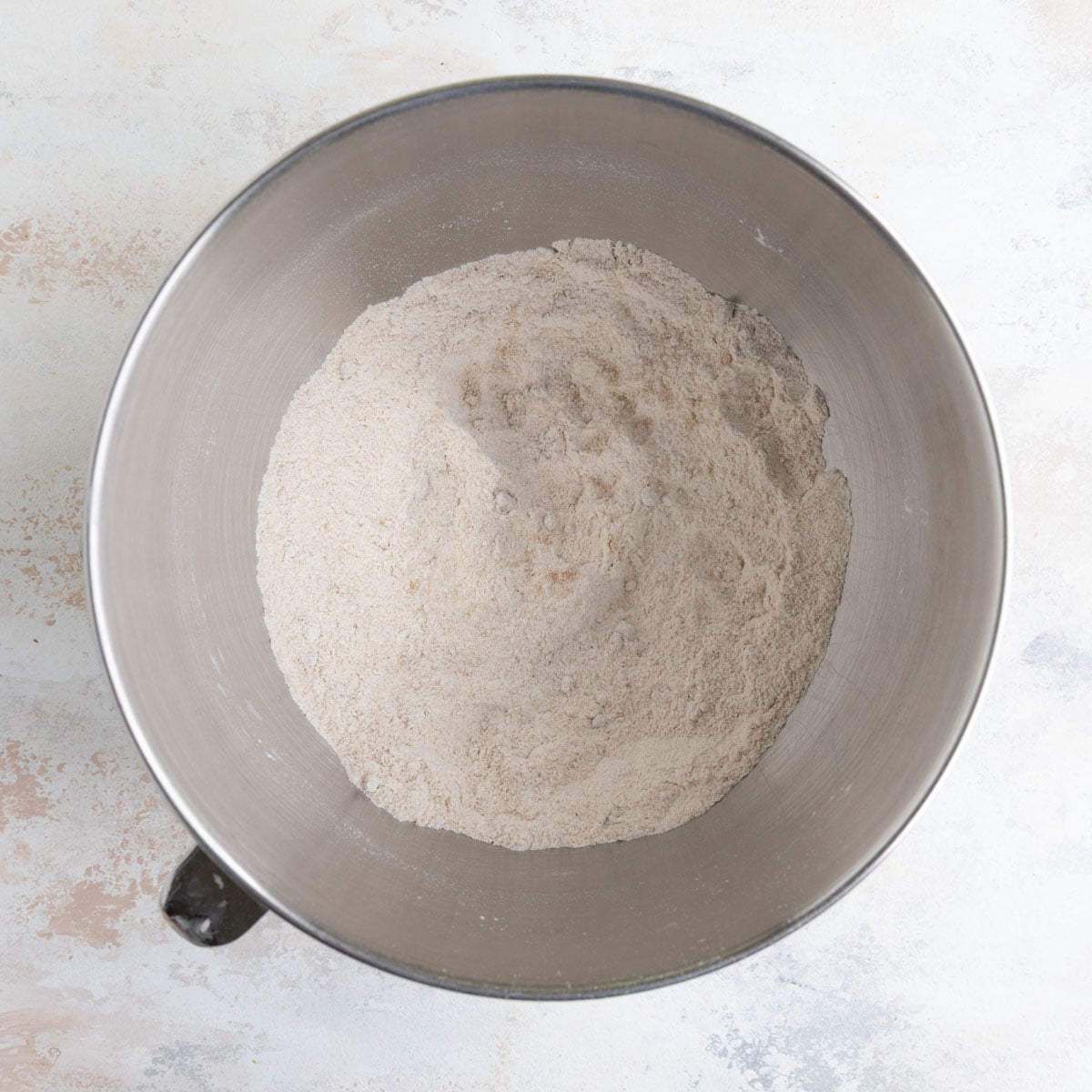Flour, white sugar, brown sugar, baking soda, and salt mixed together in the stainless steel bowl of a stand mixer