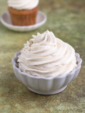 Piped vanilla ermine frosting in a white ceramic bowl