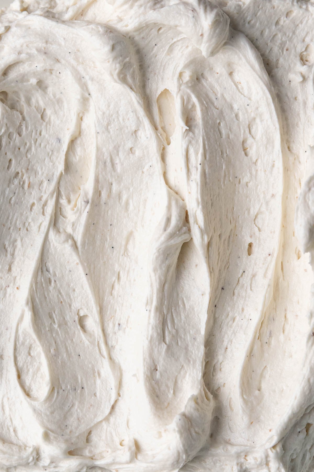Ermine frosting on plate with swirls made with a teaspoon.