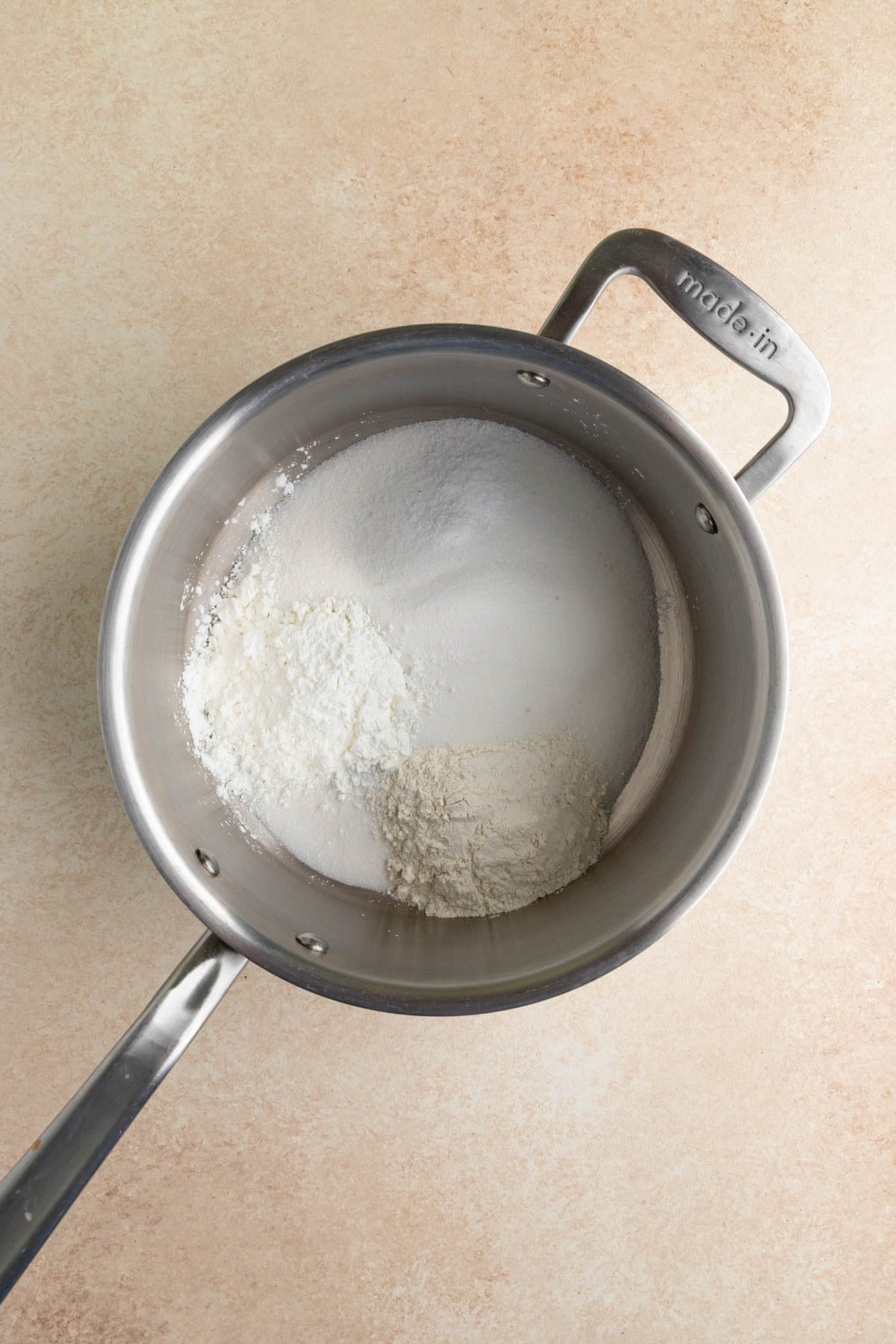 Granulated sugar, flour, cornstarch,and salt in a stainless steel saucepan.
