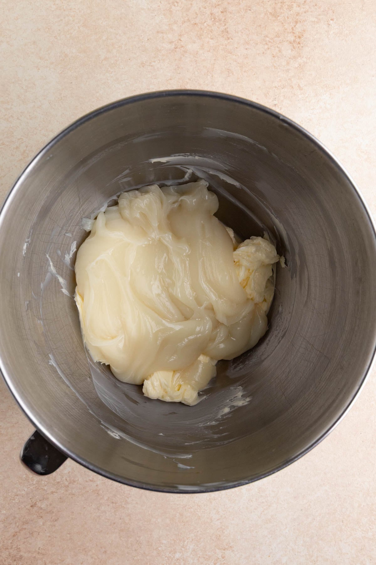 Whipped butter and the flour roux in the stainless steel bowl of a stand mixer