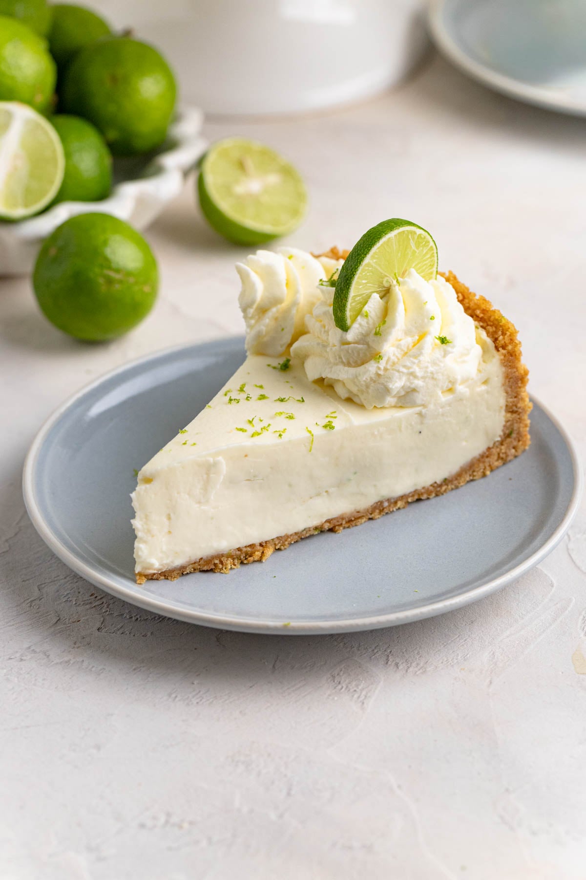 A slice of no bake key lime cheesecake on a small blue plate