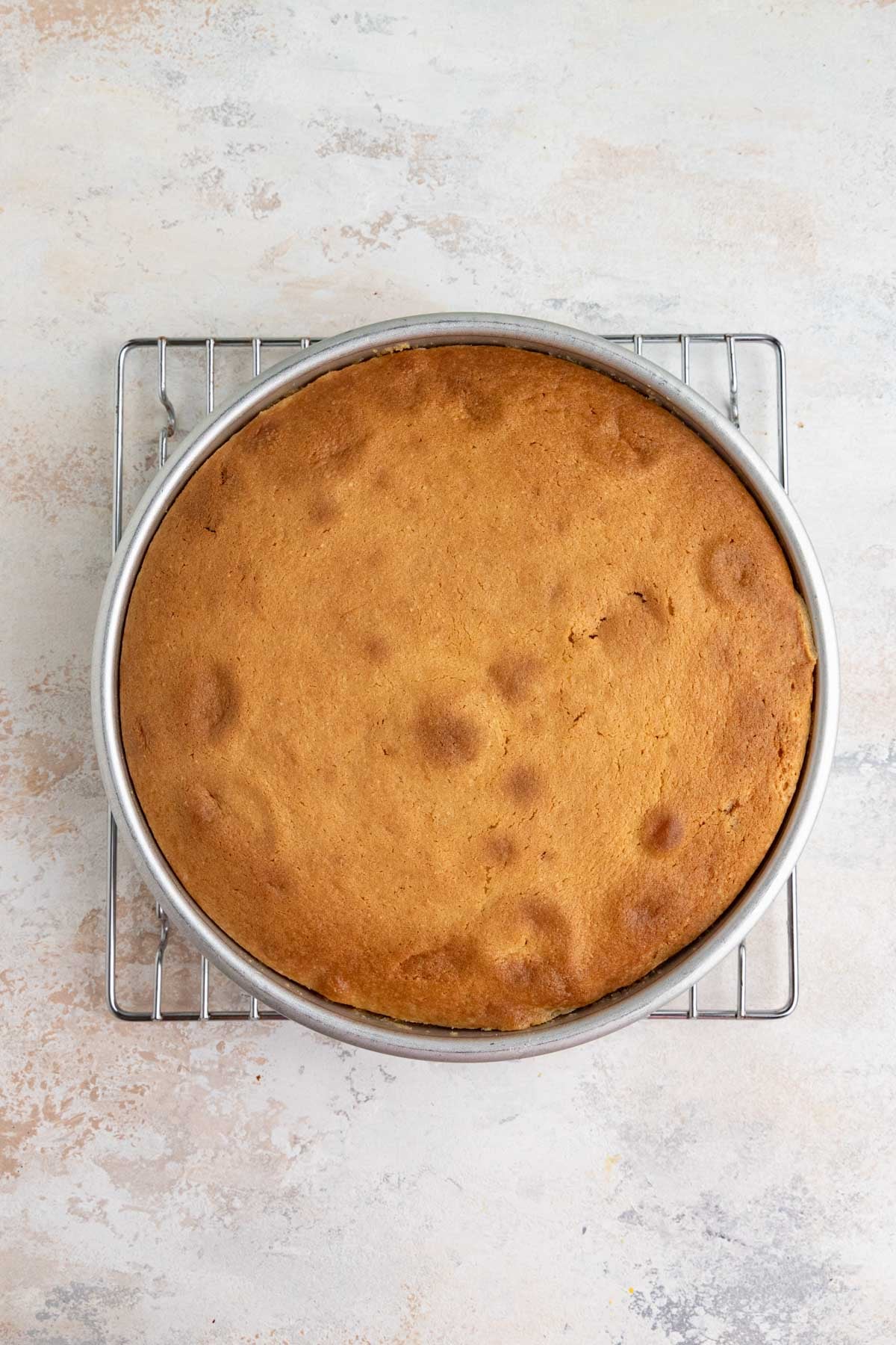 The baked can in the cake pan. The top is dark golden brown