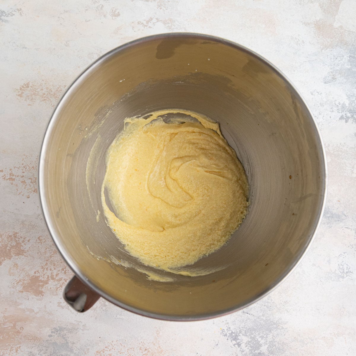 The batter in a stainless steel bowl with the eggs and vanilla mixed in.