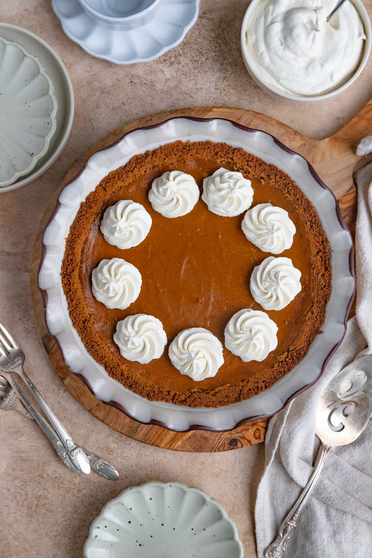Baked sweet potato pie decorated with swirls of whipped cream.