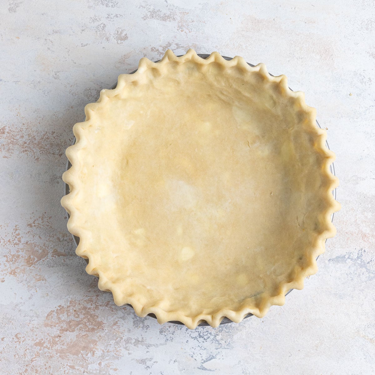 Pie dough shaped in a 9-inch pie plate with crimped edges.