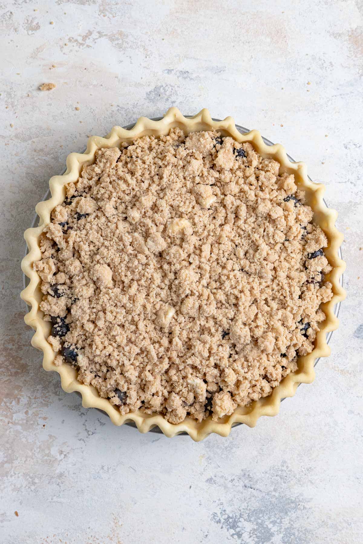 Crumble on top of blueberries in an unbaked pie shell