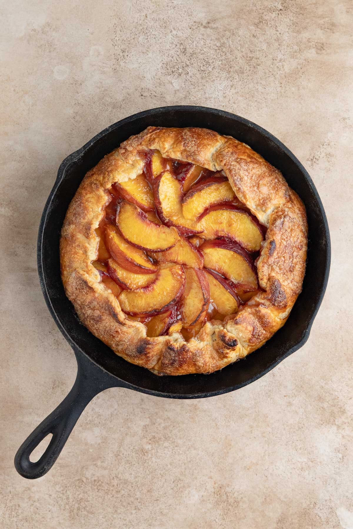 The baked peach galette in a cast-iron pan.