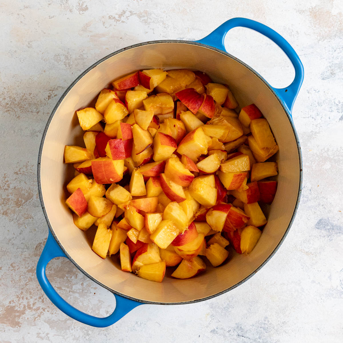 Chopped peaches in a enameled lined pot