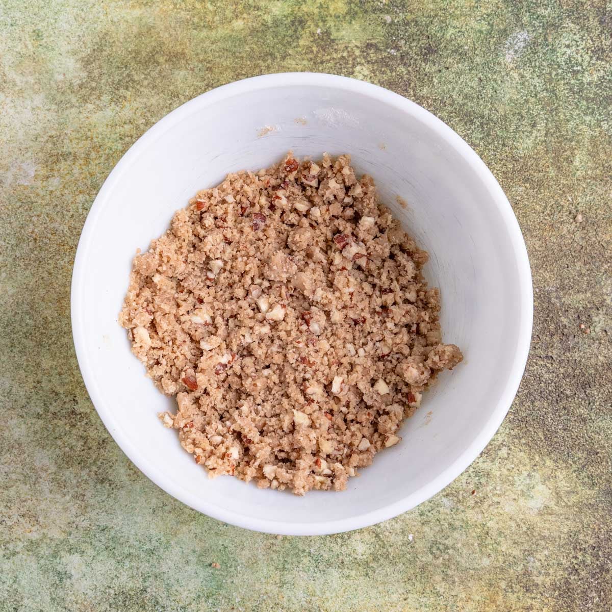 Streusel with pecans in a white ceramic bowl